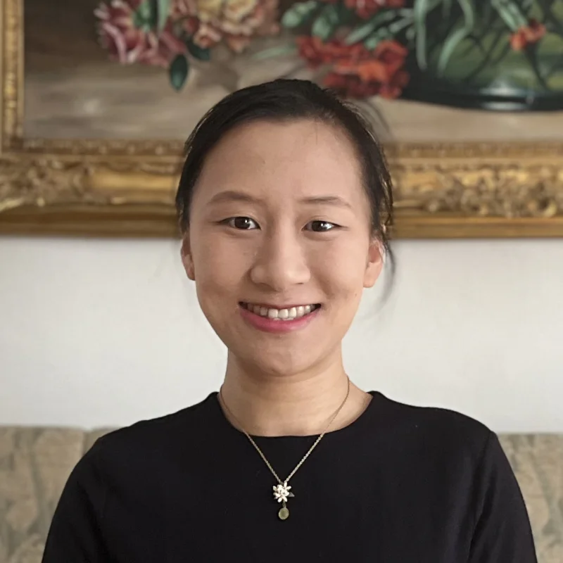 A picture of Zi in her apartment. She is smiling.